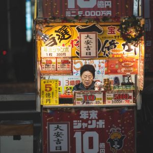 篱笆老干部闲聊区主编老梅居士的工位留影，桌上摊着分类手稿与老花镜，墙面贴着版块更新计划表，显得踏实认真